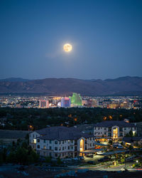 High angle view of illuminated buildings against sky at night