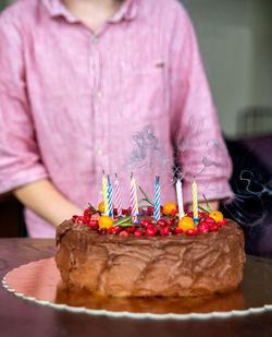 Midsection of woman holding cake