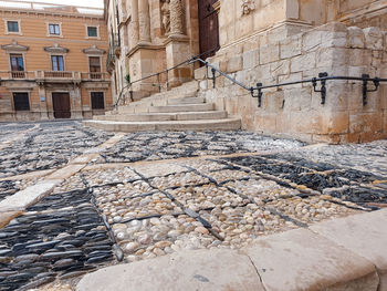 Cobblestone street amidst buildings in city