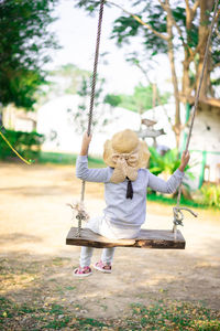 Rear view of girl on swing at playground