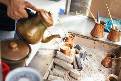 Cropped hand pouring coffee in cup