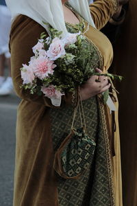 Midsection of woman holding bouquet