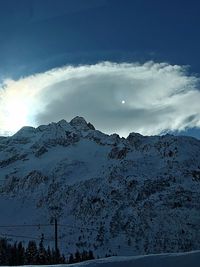 Scenic view of snowcapped mountain against cloudy sky