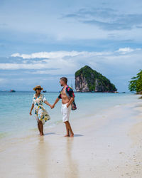 Couple holding hands standing on beach