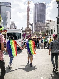 People on city street against buildings