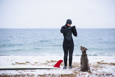 Young woman and dog going winter surfing in snow