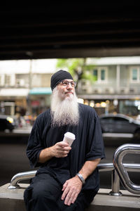 Man holding mobile phone in city