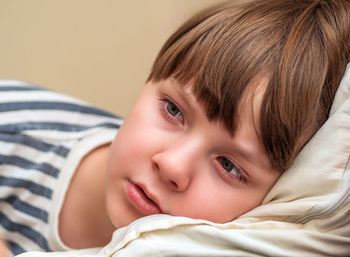 Close-up of cute baby boy lying on bed at home