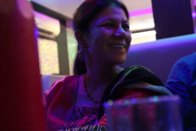 Close-up of smiling young woman sitting at home