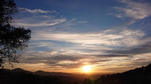 Scenic view of silhouette mountains against sky at sunset