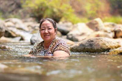 Portrait of smiling woman swimming in lake