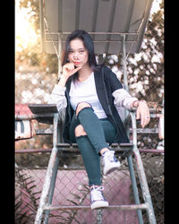 Portrait of a smiling young woman sitting outdoors