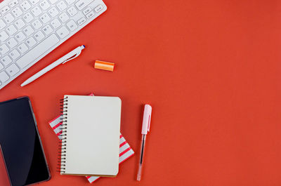 Directly above shot of office supplies over red background