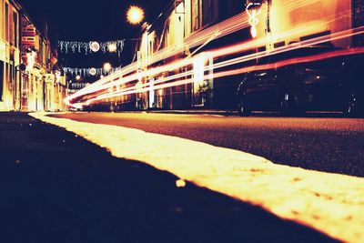 Surface level of road amidst buildings in city at night