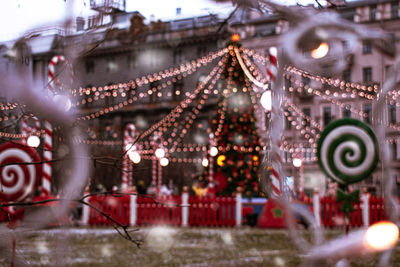 Illuminated christmas decoration and tree in city at dusk