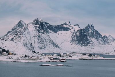 Scenic view of snowcapped mountains by sea against sky