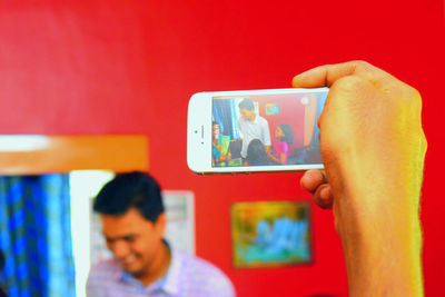 Cropped image of person photographing family in living room