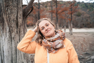 Portrait of smiling woman with snow covered tree