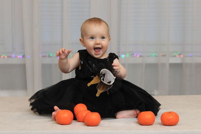Portrait of cute baby girl sitting at home