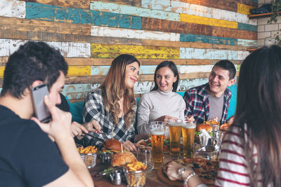 Happy friends having food at table in restaurant