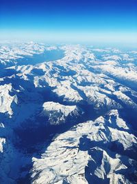 Scenic view of snowcapped mountains against blue sky