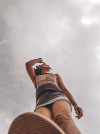 Low section of woman relaxing against sky