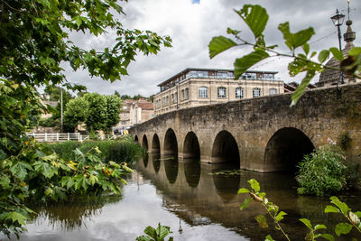 Arch bridge over water against sky