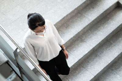 High angle view of woman sitting on staircase