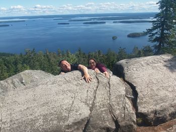 People on rock by water