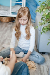 Girl with baby brother playing on the floor in a game of django