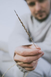 Midsection of man holding straw