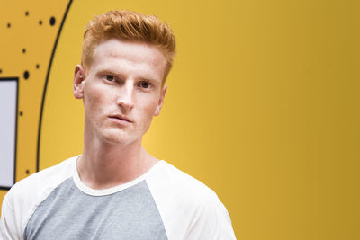 Portrait of young man against yellow background