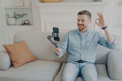 Man using mobile phone while sitting on sofa