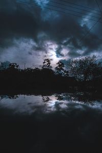 Pond against cloudy sky at dusk