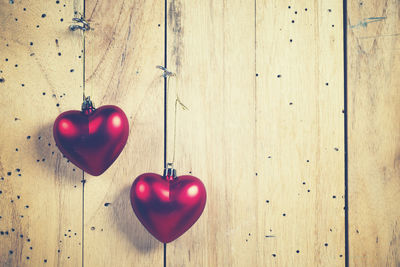 Close-up of red heart shape on table against wall