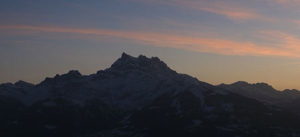 Scenic view of snowcapped mountains against sky during sunset