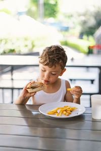 Young woman eating food on table