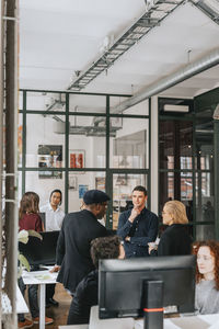 Multiracial male and female business people during meeting at work place