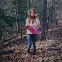 Teenage girl using landline phone in forest