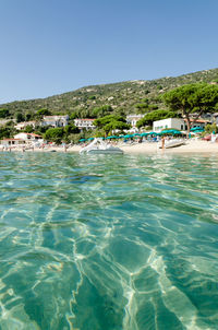 Scenic view of swimming pool by sea against clear sky