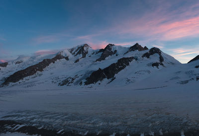 Scenic view of snowcapped mountains against sky during sunset