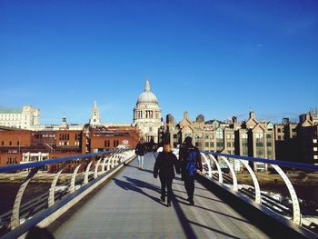 People walking on millennium bridge against st paul cathedral