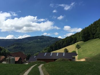 Scenic view of landscape and houses against sky