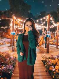 Full length portrait of woman standing at night