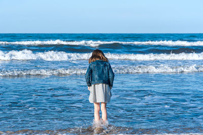 Rear view of woman standing on beach