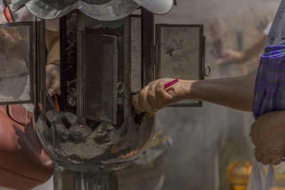 Close-up of people burning incense