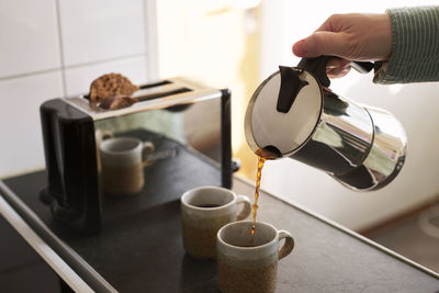 Woman pouring coffee into cup