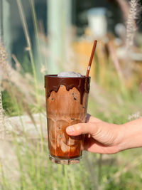 Close-up of hand holding beer glass