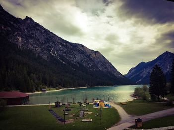 Scenic view of lake and mountains against cloudy sky