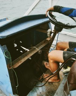 Low angle view of man sitting on abandoned boat